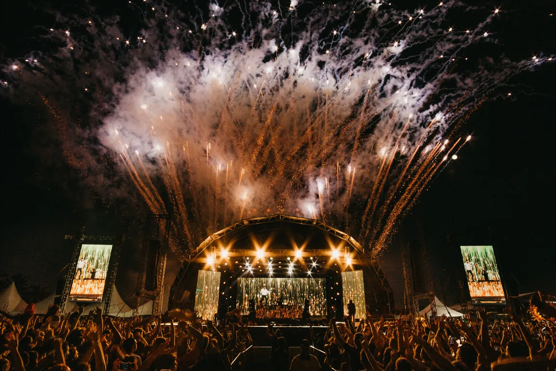 Festivalbühne mit Lichtshow und Publikum bei Nacht